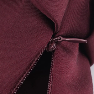 Gros plan d'une fermeture éclair invisible sur un tissu en maille bordeaux foncé chic