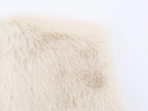 Close-up of fluffy beige faux fur material showing soft fibers and dense texture detail