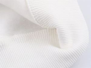 Detail von weißen Rippstrickbündchen und weichem Fleece-Futter an lässigem Sweatshirt