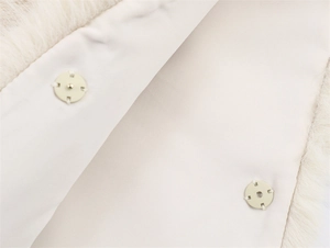 Detail of cream faux fur vest showing smooth lining and hidden snap button closure
