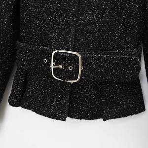 Detail of black tweed jacket featuring metallic silver threads and gold waist buckle