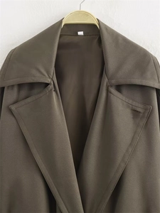 Détails du large revers et des coutures soignées du trench-coat court d'automne