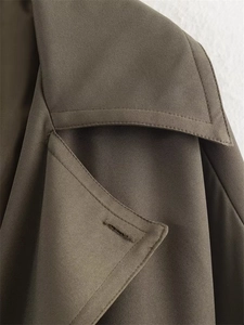 Vue macro détaillée de la texture du tissu en sergé et des coutures sur la veste kaki