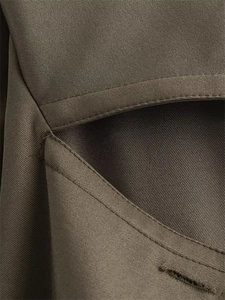 Vue macro détaillée du tissu sergé brun olive et surpiqûres doubles haut de gamme sur la veste