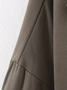Gros plan du tissu sergé marron montrant les coutures détaillées et la texture de la veste