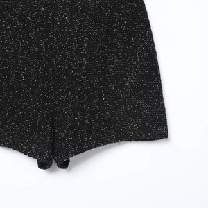 Close-up of black tweed skort fabric with silver shimmering fibers and fine stitching