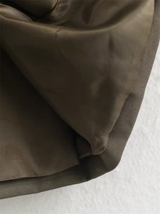 Vue macro du tissu en sergé vert olive et de la doublure soyeuse d'une veste courte