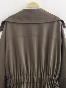 Détails de la veste tissée olive montrant la taille plissée et les coutures au dos