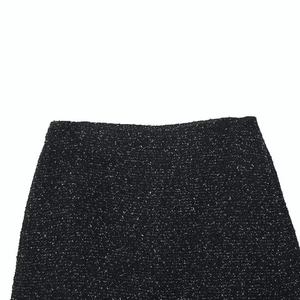 Detailed macro shot of the black and white tweed texture on a classic tailored skirt waist