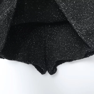 Detailed macro view of black and white tweed culottes with built-in safety lining