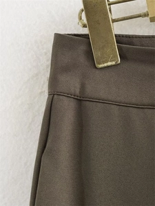 Détail de la veste en sergé marron foncé à taille haute avec coutures précises et texture