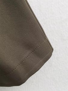 Vue macro détaillée des coutures de la veste vert olive et texture du tissu tissé