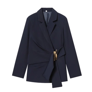 Detail of navy blue blazer featuring elegant waist pleats and decorative gold metal buckle