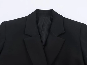 Detailed close-up of a classic notch lapel on a black blazer with premium woven texture