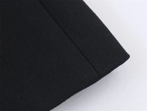 Macro detail of the edge stitching and black woven fabric texture of the suit jacket