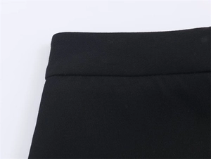 Close-up of black blazer fabric showing professional stitching and woven texture detail
