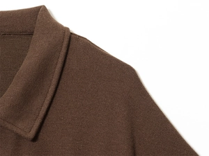 Macro detail of dark brown knit polo collar showing high-quality stitching and fabric texture