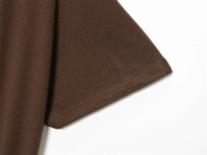Detailed close-up of double-stitched hem on a soft dark brown knit short sleeve top