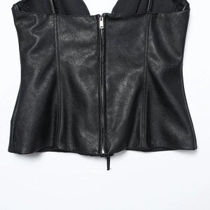 Detail eines schwarzen PU-Leder-Crop-Tops mit mittigem Metallreißverschluss am Rücken
