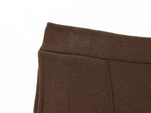 Close-up of wide ribbed elastic waistband on dark coffee knit wide-leg trousers