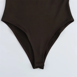 Detail view of reinforced stitching and high-cut leg opening on dark brown bodysuit
