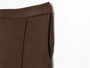 Detail of dark brown knitted wide leg trousers showing elastic waist and side pocket