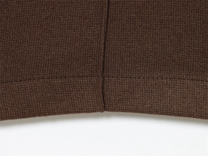 Macro shot of dark brown knit fabric showing high-quality stitching and seam detail