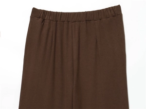 Detail of the elastic waistband and ribbed texture on dark brown wide-leg trousers