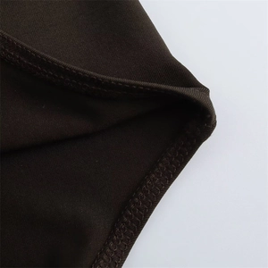Detail shot of the hemline stitching on a dark brown ribbed knit long sleeve bodysuit