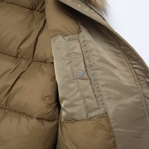 Detail of winter jacket interior with horizontal quilting and snap button pocket