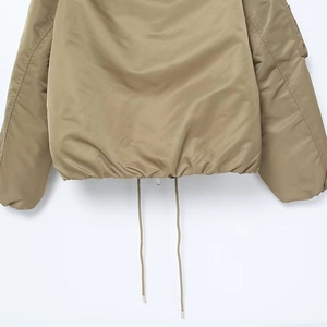 Detail of khaki jacket showing elastic drawstring hem and metallic cord ends