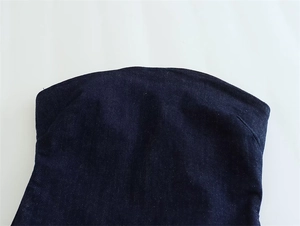 Detail of slim fit dark blue denim tube top with contoured neckline and textured fabric