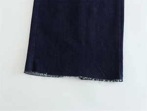 Detailed close-up of dark blue denim raw hem finish on a slim fit strapless dress
