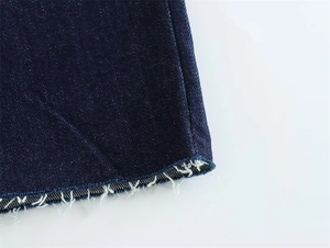 Close-up detail of the frayed hem on a dark blue denim strapless dress for women