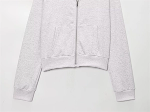 Detail view of heather grey zip-up hoodie featuring kangaroo pockets and ribbed hem texture