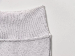 Macro shot of grey fleece trousers showing ribbed elastic waistband and stitching