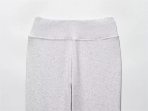 Detail of high waisted wide ribbed waistband on grey marl knit flared sports trousers
