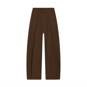 Detail view of high-waist dark brown pleated balloon trousers in smooth woven fabric