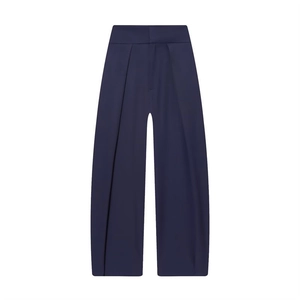 Detail view of navy blue high-waisted pleated wide-leg trousers in flowing fabric
