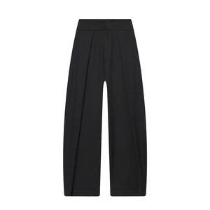 Detail of high waisted pleated wide leg trousers in black smooth fabric