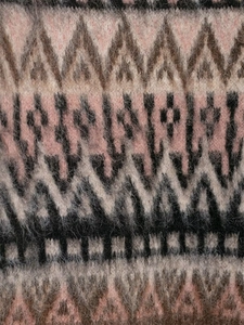 Macro view of vintage geometric jacquard knit fabric with soft brushed mohair texture
