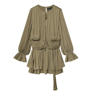 Détail d'une mini robe plissée vert olive avec ceinture et ourlet à volants étagés