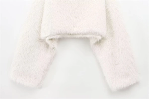 Close-up of off-white faux fur texture on the hem and cuffs of this short jacket