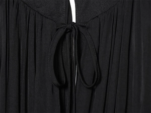 Détail de l'encolure plissée noire élégante avec un nœud délicat et une texture de tissu fin
