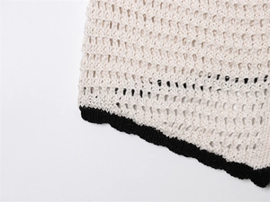 Detail eines Häkeloberteils mit schwarzem Wellensaum und Lochmuster-Textur