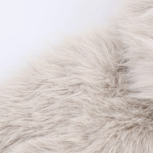 Vue macro d'une texture de fausse fourrure crème dense avec de longues fibres douces