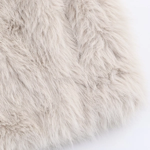 Détail de la texture douce en fausse fourrure d'une veste d'hiver crème pour femmes