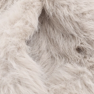 Vue macro de la texture en fausse fourrure crème douce sur une veste courte pour femmes