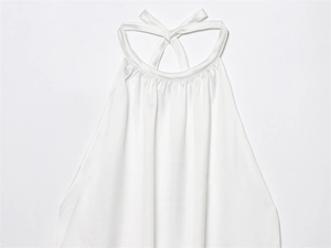 Detalle de top blanco con cuello halter y un elegante lazo de satén en la parte posterior