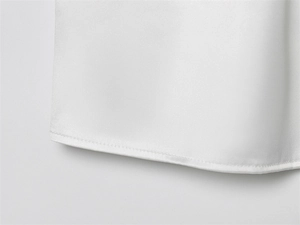 Detalle del dobladillo de doble costura de alta calidad en la tela de raso blanco liso
